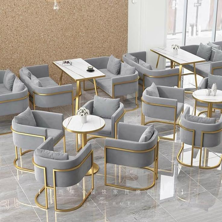 Modern café seating with grey velvet chairs and gold metal frames arranged around marble-top tables