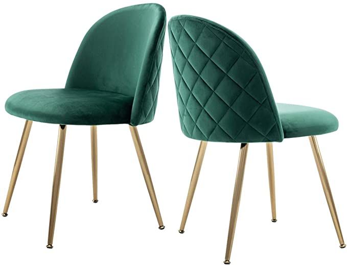 Two emerald green velvet dining chairs with quilted backs and gold metal legs in a modern elegant design.