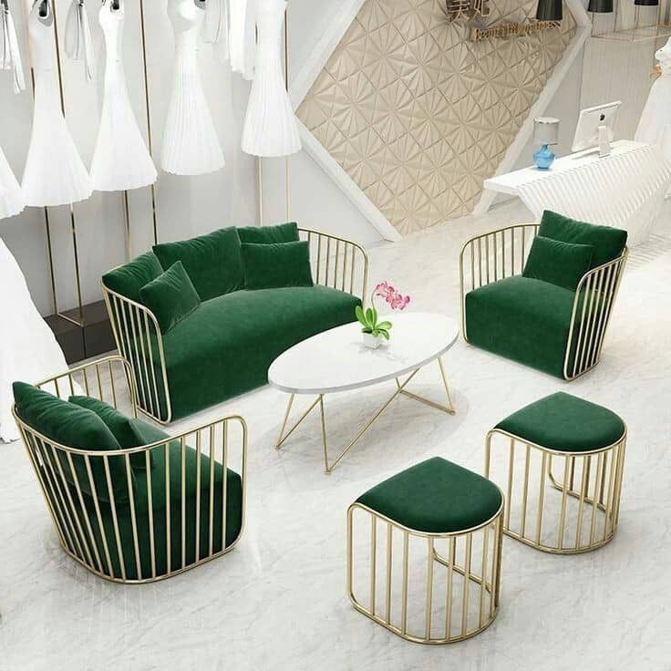 Emerald green velvet sofa set with gold metal frame, including chairs, stools, and a modern center table, perfect for elegant interiors.