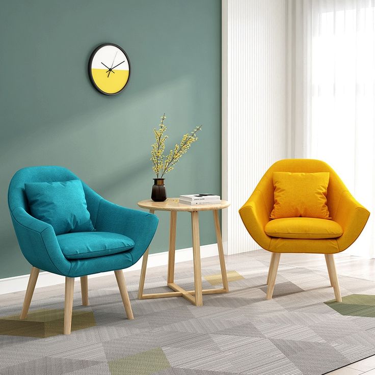 Teal and yellow modern fabric lounge chairs with wooden legs, paired with a wooden side table in a stylish living room setting.