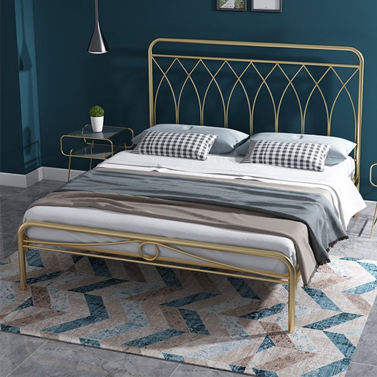 Modern metal bed frame with gold finish and upholstered panels in a stylish bedroom.