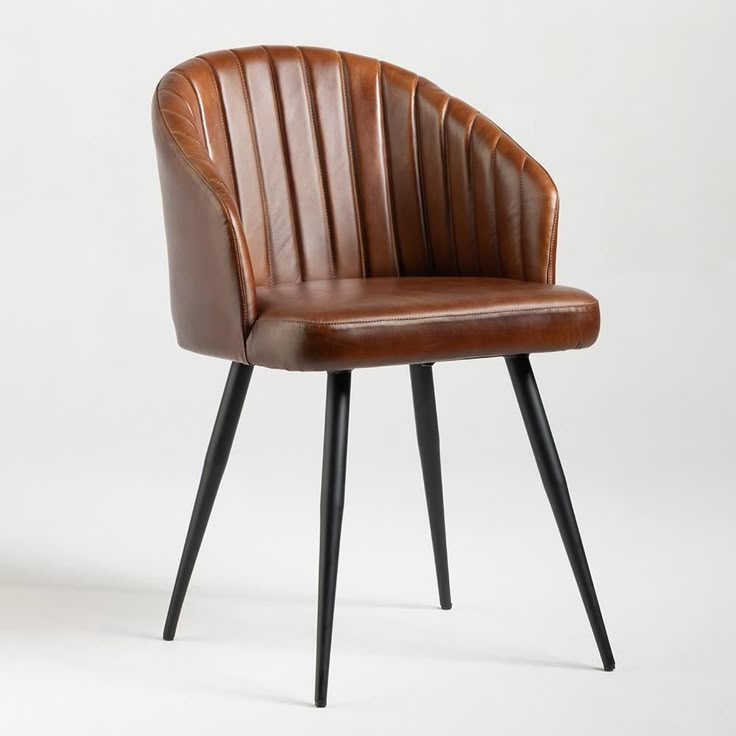 Brown faux leather barrel chair with vertical channel tufting and black metal legs