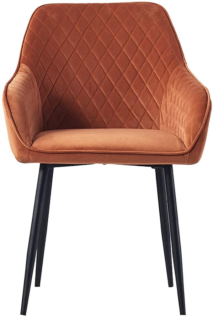 Rust-colored velvet chair with diamond pattern stitching and black metal legs, featuring a curved back and armrests.