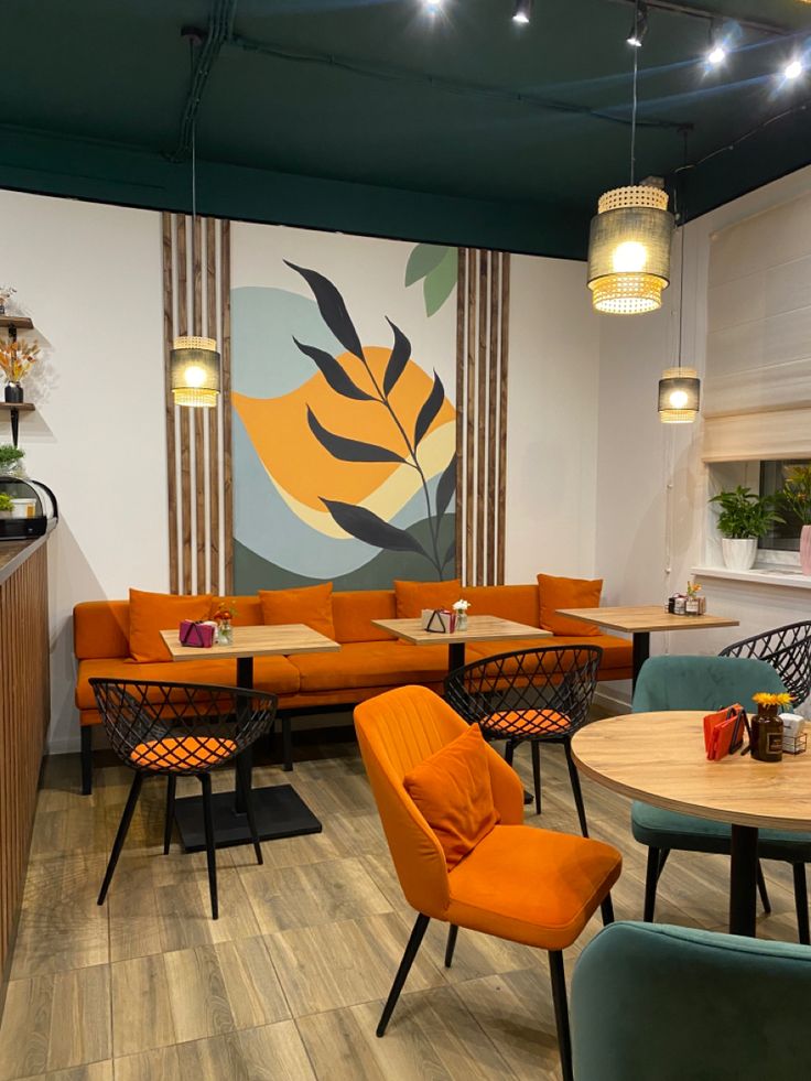 Vibrant café interior with orange and teal chairs, wooden tables, and abstract botanical wall mural