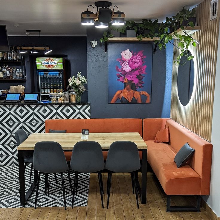 Urban café with charcoal walls, orange corner seating, bold floral wall art, and geometric patterned tiles at the bar area.